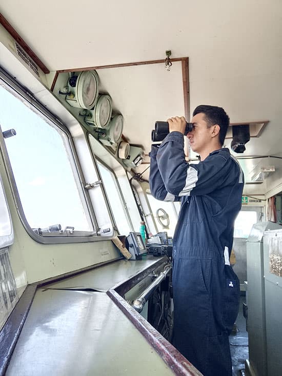 Cadet standing watch on the main deck during daytime